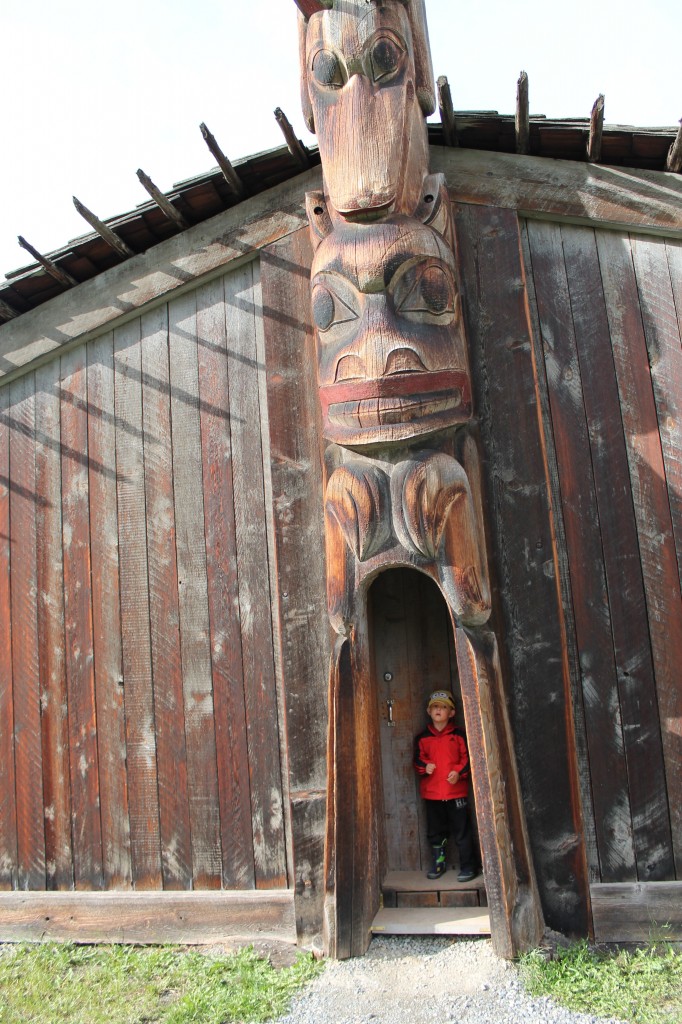 Young boy in front of a totem pole